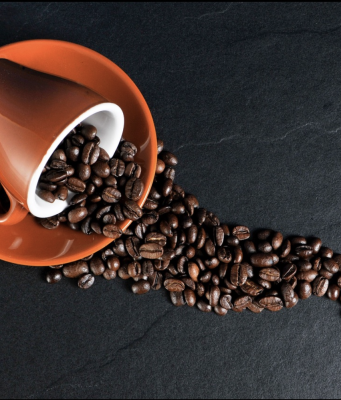 chicchi di caffè che cadono da una tazzina