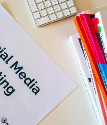 Foglio con scritto "Social Media Marketing" e accanto una pila di libri