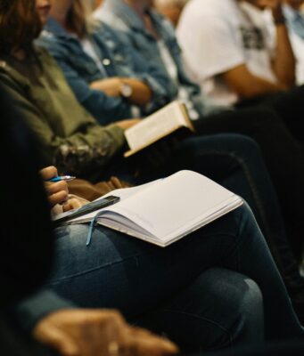Delle persone che prendomo appunti durante una conferenza