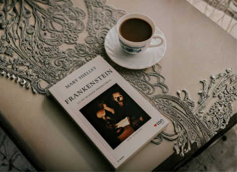 Tazza di tè e libro "Frankenstein" di Mary Shelley su un tavolo